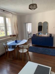 uma sala de estar com uma mesa e cadeiras e um armário azul em BELLA BLU em Opole