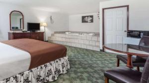 a hotel room with a bed and a desk and a tub at Best Stay Inn in Melville