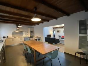 Villa Isabel في سان بارتولومي: مطبخ وغرفة طعام مع طاولة وكراسي خشبية
