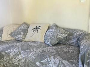 a couch with pillows on it in a room at Paparei Beachfront Bungalows, Aitutaki in Arutanga