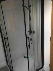 a glass shower with a glass door in a bathroom at Teach Dunmore in the heart of Donegal Gaeltacht. in Falcarragh