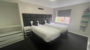 a bedroom with two beds and a window at Hosted By Ryan - 2 Bedroom Apartment in Liverpool