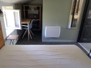 ein Schlafzimmer mit einem Bett, einem Tisch und einem Spiegel in der Unterkunft Petite maison type Loft en plein bourg d'Ambazac in Ambazac