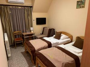 a hotel room with two beds and a desk at Hotel Dva Goluba in Pale