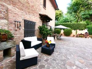 un patio con sofás y sillas en un edificio de ladrillo en Casa Lazzaro al centro di Siena en Siena