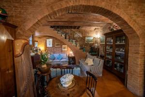 sala de estar con pared de ladrillo y escalera de caracol en Casa Lazzaro al centro di Siena, en Siena
