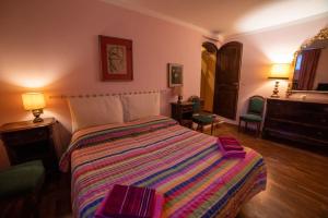 a bedroom with a bed and two chairs and a dresser at Casa Lazzaro al centro di Siena in Siena