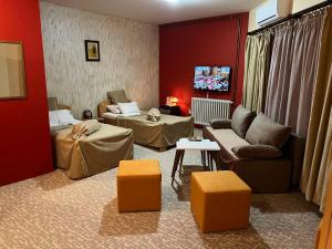 een woonkamer met rode muren en een bank en stoelen bij Hotel Dva Goluba in Pale