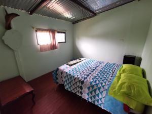 Hostal de la montaña ecoturismo في Mocoa: غرفة نوم بسرير ونافذة