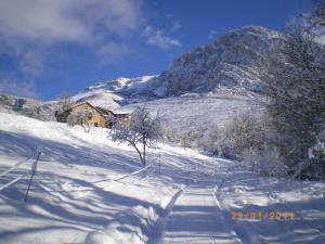 einen schneebedeckten Berg mit einem Haus im Hintergrund in der Unterkunft Albergue Casa Fumenal in Padarniu