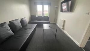a living room with a couch and a table at Hosted By Ryan - 2 Bedroom Apartment in Liverpool