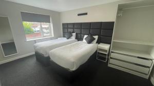 a hotel room with two beds and a window at Hosted By Ryan - 2 Bedroom Apartment in Liverpool