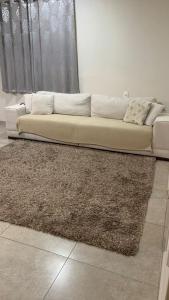 a white couch sitting in a living room with a rug at Dom Ângelo Hospedagem in Bento Gonçalves