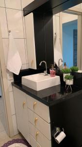 W łazience znajduje się biała umywalka i lustro. w obiekcie Dom Ângelo Hospedagem w mieście Bento Gonçalves