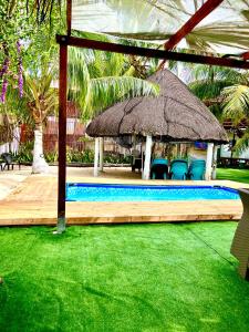 a swimming pool with a umbrella and some chairs at MIRADOR DE BARU in Cartagena de Indias