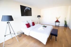 Schlafzimmer mit einem weißen Bett und roten Kissen in der Unterkunft Appartement spacieux vue Cathédrale in Reims