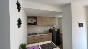 a small kitchen with a refrigerator and a table at Apartamentos nuevos, comodos, amplios y moderno OK in Gaira