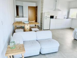 a living room with a white couch and a table at MiMar Jávea in Jávea