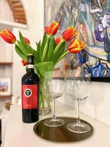 eine Flasche Wein und zwei Weingläser auf dem Tisch in der Unterkunft Home Milù Florence in Florenz