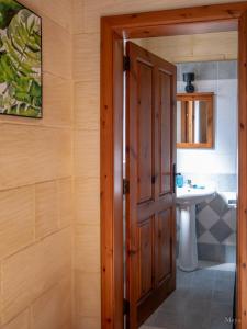 a bathroom with a wooden door and a sink at Sunny Villa in Nadur