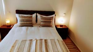 - une chambre avec un grand lit blanc et des oreillers dans l'établissement Apartamento El Castillo, à La Adrada