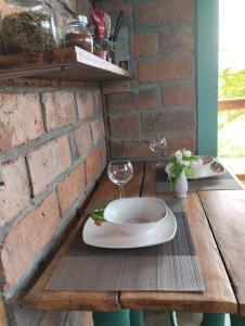 una mesa de madera con un plato y copas de vino. en Charming - 2 Storey Eco-Home, en Olón