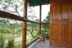 una puerta de madera abierta de un porche con un barril en Charming - 2 Storey Eco-Home, en Olón