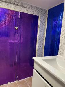 een paarse douche in een badkamer met een wastafel bij Alfama Guest House in Lissabon