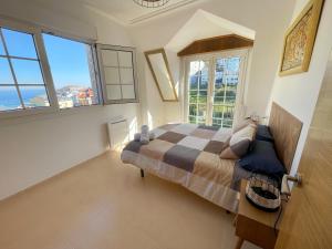 1 dormitorio con 1 cama en una habitación con ventanas en Ático oceánico, en Malpica de Bergantiños