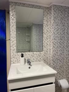 een badkamer met een witte wastafel en een spiegel bij Alfama Guest House in Lissabon