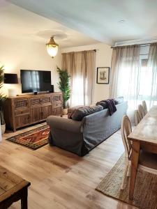 uma sala de estar com um sofá e uma televisão de ecrã plano em Artist Vintage Apartment near Center and Beaches em Esplugues de Llobregat