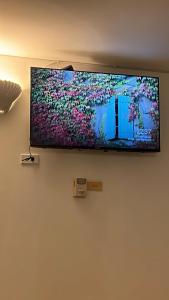 TV de pantalla plana colgada en la pared en Apartamento con salida a la playa, en Santa Marta