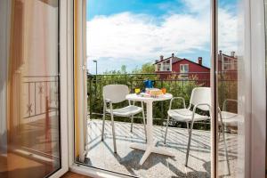 a balcony with a table and chairs on a patio at Apartments Bella B in Rovinj