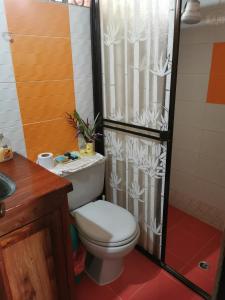 a bathroom with a toilet and a shower curtain at Hostal de la montaña ecoturismo in Mocoa