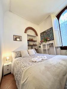 Schlafzimmer mit einem Bett und einem Fenster in der Unterkunft Home Milù Florence in Florenz