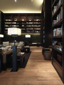 uma biblioteca com um sofá e cadeiras e um candeeiro em The Puli Hotel And Spa em Xangai