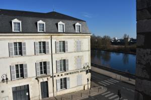 a building next to a river next to a building at Quiétude au Bord de Loire. in Orléans