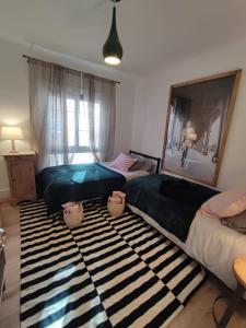 a bedroom with two beds and a rug at Artist Vintage Apartment near Center and Beaches in Esplugues de Llobregat