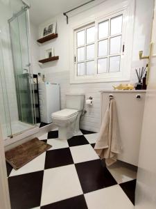 a bathroom with a toilet and a checkered floor at Artist Vintage Apartment near Center and Beaches in Esplugues de Llobregat