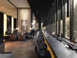 a lobby with a long line of chairs and tables at The Puli Hotel And Spa in Shanghai