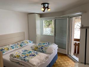 St. Moritz في سان موريتز: سريرين في غرفة صغيرة مع نافذة