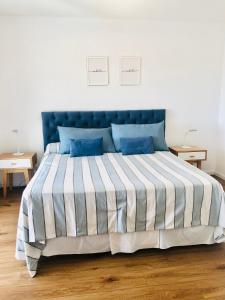 a bedroom with a large bed with blue and white stripes at Fantástico depto. con vistas panorámicas in Vicente López