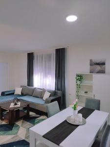 ein Wohnzimmer mit einem Sofa und einem Tisch in der Unterkunft SAMI APARTMAN in Niš