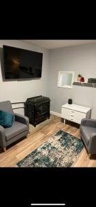 a living room with two couches and a flat screen tv at Ramulligan Cottage in Cavan