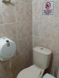 a bathroom with a toilet and a no smoking sign at Casa turística Erikmar in Gaira