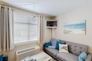 sala de estar con sofá y ventana en The Oceanfront Litchfield Inn 251 en Pawleys Island