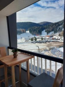 d'un balcon avec une table et une vue sur la montagne. dans l'établissement Luxury Apartment Zimska idila, à Bjelašnica