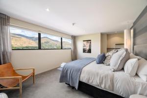 a bedroom with a bed and a large window at Hana Apartment by Sotheby's Luxury Rental Homes in Wanaka