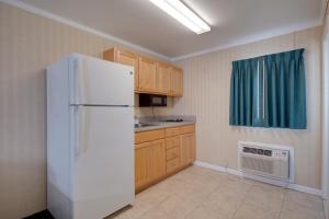 a kitchen with a white refrigerator and wooden cabinets at Sahara Motel in Ocean City