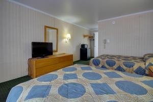 a hotel room with two beds and a flat screen tv at Sahara Motel in Ocean City